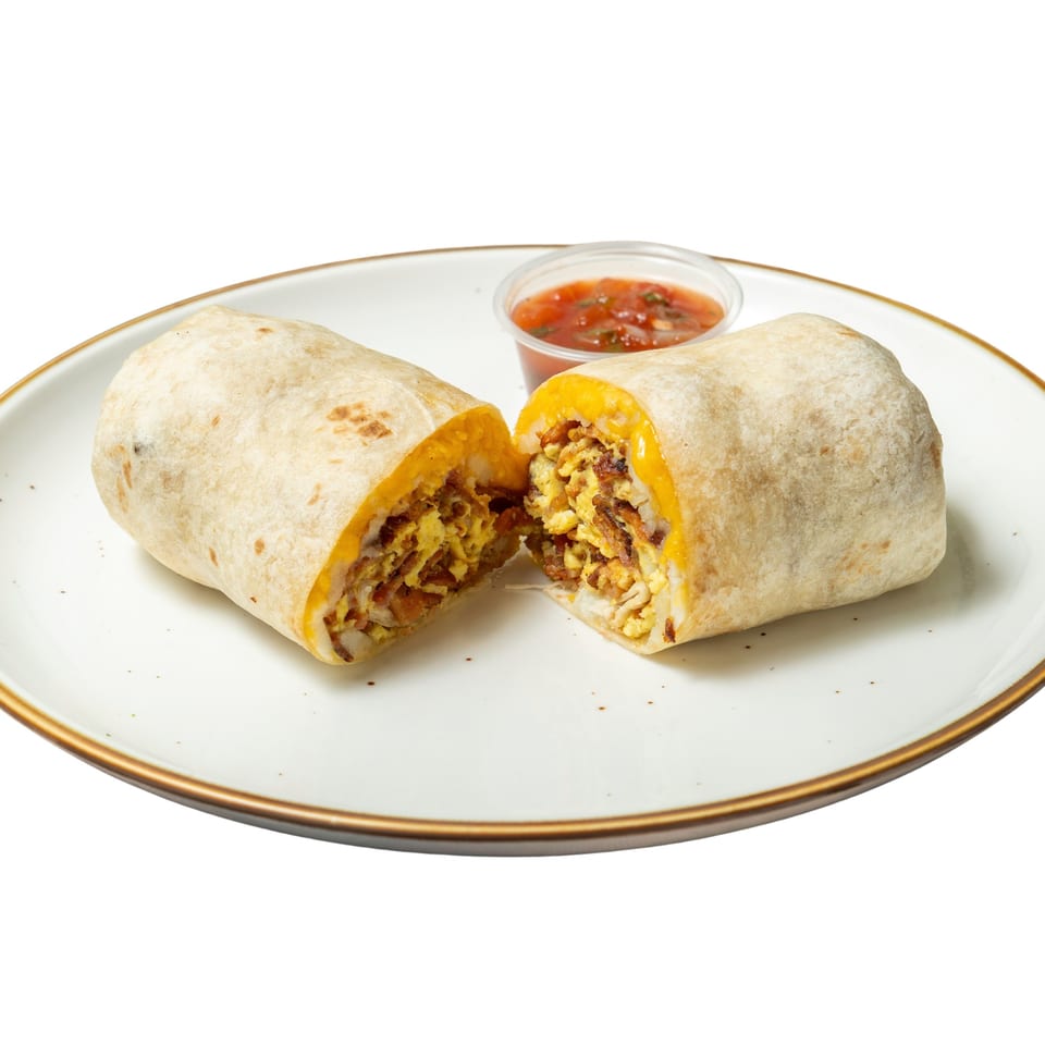 Breakfast burrito, cut in half, revealing scrambled eggs, bacon, and cheese, with a side of salsa.